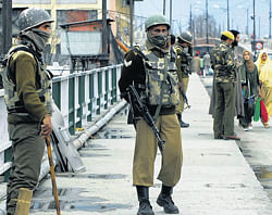 Troubled times: Security personnel stand guard on a street in Srinagar on Sunday. PTI