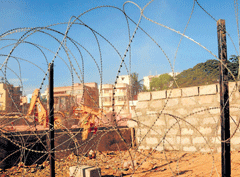 Cross-border: Men from 515 Base Workshop have fenced the wall which they built at midnight on Saturday blocking the right of way to service road. The incident at Gauthamapura triggered a protest on Sunday. dh Photo