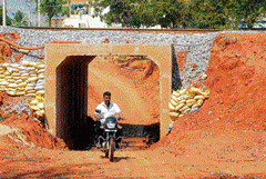 muddy stretch: The residents are facing a lot of inconveniences due to the construction of the underpass, that is both narrow and short near Kuppahalli village in Chikkaballapur taluk. DH Photo