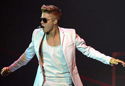 This March 22, 2013 file photo shows Canadian singer Justin Bieber performing on stage in Zurich, Switzerland. Bieber's neighbor in Southern California has accused the pop singer of battery and making threats during an argument. (AP Photo