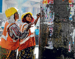 Clean up act: BBMP workers remove posters at T Dasarahalli on Nelamangala Road on Thursday. DH Photo