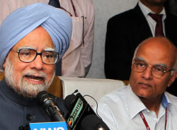 Prime Minister Manmohan Singh addressing an onboard press conference during his return journey after concluding the fifth BRICS Summit in Durban, South Africa, in the VVIP flight on Thursday. NSA Shiv Shanker Menon is also seen. PTI Photo