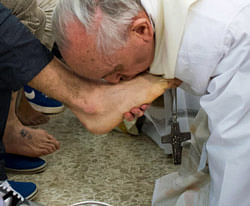 In this photo provided by the Vatican newspaper L'Osservatore Romano, Pope Francis kisses the foot of an inmate at the juvenile detention center of Casal del Marmo, Rome, Thursday, March 28, 2013. Francis washed the feet of a dozen inmates at the juvenile detention center in a Holy Thursday ritual that he celebrated for years as archbishop and is continuing now that he is pope. Two of the 12 were young women, an unusual choice given that the rite re-enacts Jesus' washing of the feet of his male disciples. The Mass was held in the Casal del Marmo facility in Rome, where 46 young men and women currently are detained. Many of them are Gypsies or North African migrants, and the Vatican said the 12 selected for the rite weren't necessarily Catholic. AP Photo