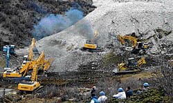 Earthmovers remove rocks and mud at the scene of  a landslide in Tibet on Friday. AP
