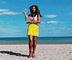 Picture perfect: Serena Williams poses with the trophy on the beachside in Miami on Sunday. AFP
