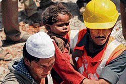 SAVING&#8200;LIVEs:  Rescue work in progress at the site of the collapsed building in Thane, Mumbai on Friday(L). Rescue workers carry a  child who survived a building collapse. The half-finished building that was being constructed illegally in a suburb of India's financial capital collapsed on Thursday, killing 56 people and injuring more than 50 others, police said on Friday. Agencies
