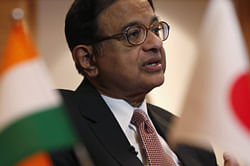 Finance Minister Palaniappan Chidambaram speaks behind Indian (L) and Japanese national flags during an interview with Reuters in Tokyo April 2, 2013. Chidambaram suggested on Tuesday that the government is unlikely to raise the import tax on gold further to avoid gold smuggling and would instead introduce inflation-indexed instruments to help curb a record current account deficit. Reuters photo