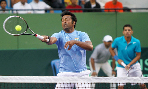 Leander Paes (L) plays a shot against Indonesia's David Agung Susanto and Elbert Sie as his partner Sanam Singh looks on during Davis Cup Asia/Oceania Zone Group I play-off first round doubles match in Bengaluru on Saturday. PTI Photo by Shailendra Bhojak