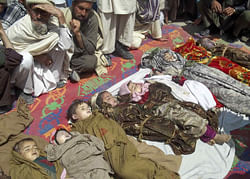 Afghan villagers sit near the bodies of children who they said were killed during an air strike in Kunar province April 7, 2013. Eleven children and a woman were killed by an air strike during a NATO operation targeting Taliban commanders in eastern Afghanistan, officials in the region said Sunday. REUTERS photo