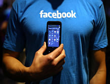 A Facebook employee holds a phone that is running the new 'Home' program during an event at Facebook headquarters during an event at Facebook headquarters on April 4, 2013 in Menlo Park, California. Facebook CEO Mark Zuckerberg announced a new product for Android called Facebook Home as well as the new HTC First phone that will feature the new software. AFP photo