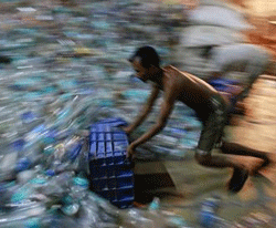 A man collects empty plastic bottles to be recycled at a factory in a slum in Mumbai March 15, 2013.  Credit: Reuters