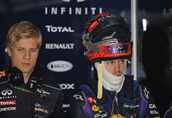 Red Bull driver Sebastian Vettel of Germany (R) gets ready for the third practice session of the Formula One Chinese Grand Prix in Shanghai on April 13, 2013. AFP PHOTO