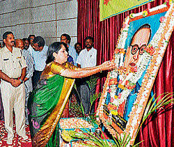 Deputy Commissioner M V Savitri pays floral tributes to portrait of Dr B R Ambedkar in Chamarajanagar.