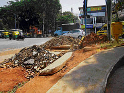 Piles of debris left uncleared on a dug-up road at Banashankari 3rd Stage have been causing huge inconvenience to pedestrians and motorists. DH Photo