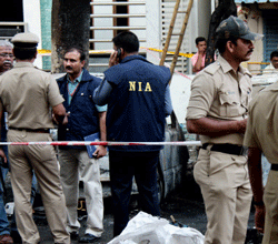 Indian National Investigative Agency officers investigate a blast site near the Bharatiya Janata Party (BJP) office at Malleshwaram in Bangalore on April 17, 2013. Police in the southern city of Bangalore said Wednesday they were investigating a minor blast outside the office of a political party which injured 12 people. AFP PHOTO