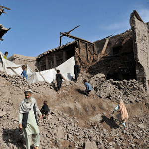 Afghan residents walk on a home destroyed by a powerful earthquake in Charbagh village in Nangarhar province on April 24, 2013. Seven people were killed, dozens injured and many homes destroyed when a powerful earthquake struck eastern Afghanistan on Wednesday, officials said. AFP PHOTO