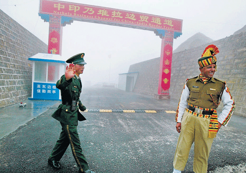 A Chinese soldier (L) and an Indian soldier stand guard at the Chinese side of the ancient Nathu La border crossing between India and China. AFP file photo
