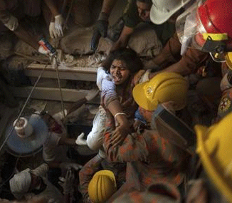 Rescue workers rescue a garment worker from the rubble of the collapsed Rana Plaza building, in Savar, 30 km (19 miles) outside Dhaka April 27, 2013.  Credit: Reuters/