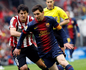 Barcelona's Lionel Messi passes Athletic Bilbao's Mikel San Jose during their Spanish first division soccer match at San Mames stadium in Bilbao, April 27, 2013. REUTERS