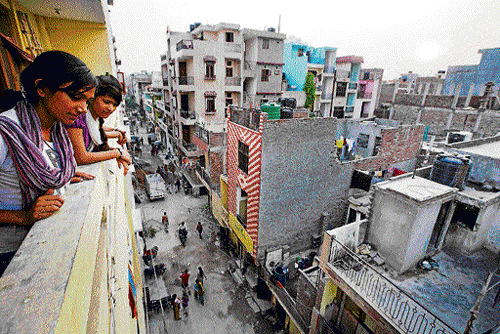 urban chaos: Residents look out of their balcony in New Ashok Nagar, an "unauthorised colony" in New Delhi. NYT