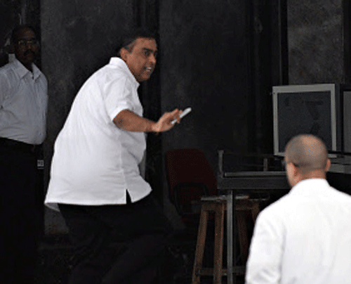 Mukesh Ambani (2nd R) walks into his office in Mumbai on April 22, 2013. The Indian government is to provide the country's richest man Mukesh Ambani, head of energy giant Reliance Industries, with full-time security from armed commandos, media reports said. AFP PHOTO