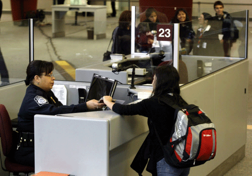 A foreign airline passenger is greeted by a Customs and Border Protection Officer at Hartsfield-Jackson International Airport in Atlanta, Georgia in this January 5, 2004 file photo. The Department of Homeland Security, criticized for failing to check the student status of a Kazakh man charged in the aftermath of the Boston Marathon bombing, has tightened procedures for admitting foreigners with student visas, a U.S. official said on Friday. The Department's Customs and Border Protection issued a memo ordering agents 'effective immediately' to check all students against the Student and Exchange Visitor Information System database of international students and schools, according to an official who had seen the memo. REUTERS