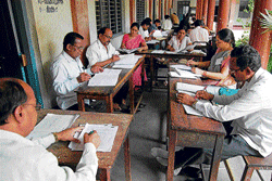 A file picture of teachers evaluating SSLC answer papers.