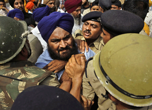 Police try to stop a Sikh protester as he protests the acquittal of ruling Congress party leader Sajjan Kumar of charges that he incited mobs to kill Sikhs during the country's 1984 anti-Sikh riots in New Delhi, Sunday, May 5, 2013. Kumar had faced a possible death sentence if he had been convicted of inciting a mob in the capital to kill a family of Sikhs in the violence that followed the assassination of Prime Minister Indira Gandhi by her Sikh bodyguards. More than 3,000 Sikhs were killed during the riots. AP Photo