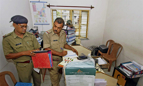 Police personnel investigating documents of chit fund company Saradha Group after breaking the lock of its branch office at Bolpur in Birbhum district in West-Bengal on Sunday. PTI Photo