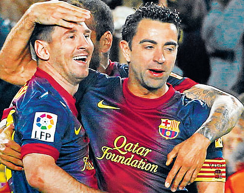 prolific: Barcelona's Lionel Messi (left) and Xavi Hernandez celebrate a goal against Real Betis during their Spanish league match in Barcelona on Sunday. reuters