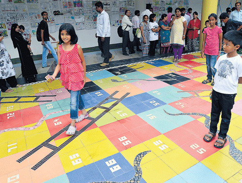 Fun time: Children play a giant version of 'Snakes and Ladders' at the Rangoli Art Centre on Monday. dh photo