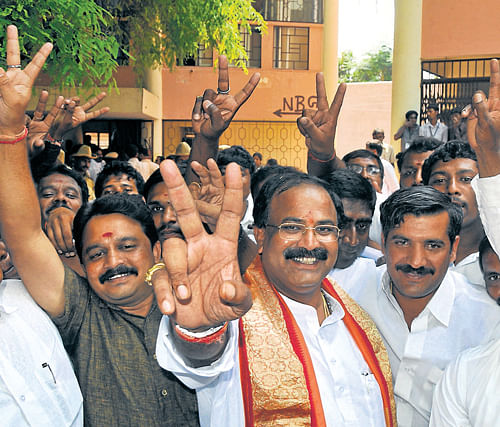 triumphant: Mahadevpura BJP candidate Aravind Limbavali flashes the victory sign along with his supporters in Bangalore on Wednesday. dh Photo