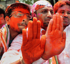 Congress party supporters show their hands, smeared with colour, as they celebrate their victory in Karnataka Assembly elections, in Bengaluru on Wednesday. PTI Photo