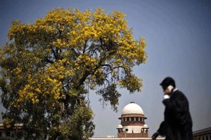 A lawyer speaks on his mobile phone as he walks past the Supreme Court in New Delhi April 1, 2013. REUTERS