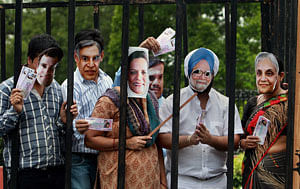 Bharatiya Janata Yuva Morcha members wear masks during a protest near Prime Minister's residence demanding his resignation, in New Delhi on Sunday. PTI Photo by Kamal Singh