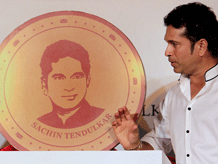 Cricketer Sachin Tendulkar displays a 10 gram gold coin embossed with his face during its unveil on the occasion of "Akshay Tritiya" in Mumbai, Monday, May 13, 2013. The coin will cost Rs 34,000. The festival is considered auspicious for buying gold among other things. (AP Photo