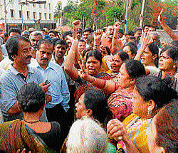 MLA Vasu and MCC Commissioner P G Ramesh listen to the grievances of Paduvarahalli residents, who staged a protest against irregular water supply on Hunsur road, in Mysore, on Tuesday. dh photo