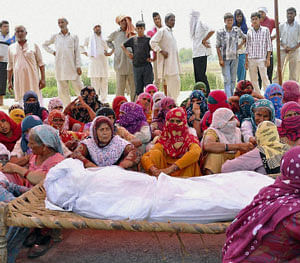 Arya Samaj activists protest with the body of 40-year-old Promila on Rohtak-Jhajjar road near Satlok Ashram and refused to disperse till their release of their arrested in connection with the yesterday's clash. on Monday. PTI Photo