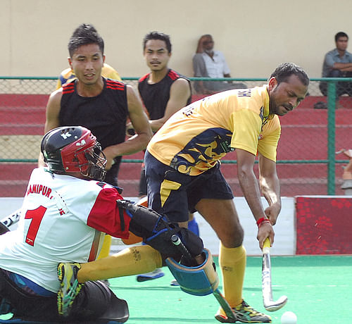 Prem Kumar of Uttar Pradesh moves with ball who scored against Manipur as K Urun (GK) of Manipur trying to stop him, during their 64th Rangaswamy Cup Senior National Hockey Championship in Bangalore on Wednesday. DH Photo
