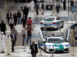 Visitors pass by a Lamborghini Aventador, foreground, and a Bentley Continental GT Coupe, both used as police cars, at the Arabian Travel Market in Dubai, United Arab Emirates, Thursday, May 9, 2013. AP Photo