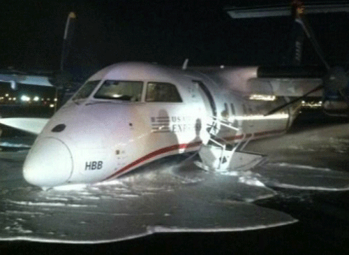 In this image taken from video and provided to WABC TV News by an airport source, emergency personnel spray foam on the fuselage of a US Airways Express commuter plane after it made a belly landing at Newark Liberty International Airport, Saturday, May 18, 2013, in Newark, N.J. The turboprop plane reportedly left Philadelphia shortly before 11 p.m., Friday, and landed safely at Newark with its landing gear retracted at about 1 a.m., Saturday. There were no injuries. (AP Photo