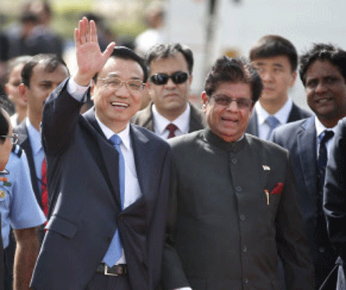 Chinese Premier Li Keqiang waves as he is received by Junior minister for external affairs, E. Ahamed, right, after he arrived in New Delhi, Sunday, May 19, 2013. Just weeks after a tense border standoff, China's new premier arrived in India on Sunday for his first foreign trip as the neighboring giants look to speed up efforts to settle a decades-old boundary dispute and boost economic ties. AP Photo