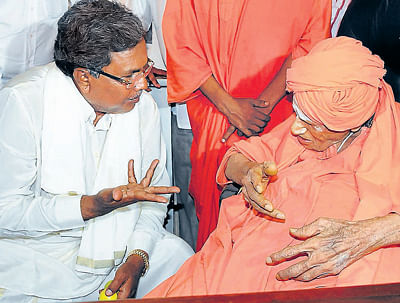 Chief Minister Siddaramaiah interacts Siddaganga Mutt seer Shivakumar  swami at the Basava Jayanti programe in Bangalore on Sunday.  DH Photo