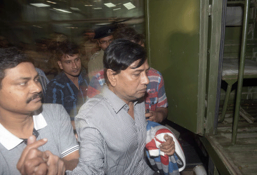 Police officials escort Chit-fund company Saradha Group's Chairman Sen to a police van outside the airport on his arrival in Kolkata. Reuters