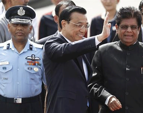 Chinese Premier Li Keqiang (C) waves upon his arrival as India's Minister of State for External Affairs E. Ahmed watches upon his arrival at the airport in New Delhi May 19, 2013.  Credit: Reuters/