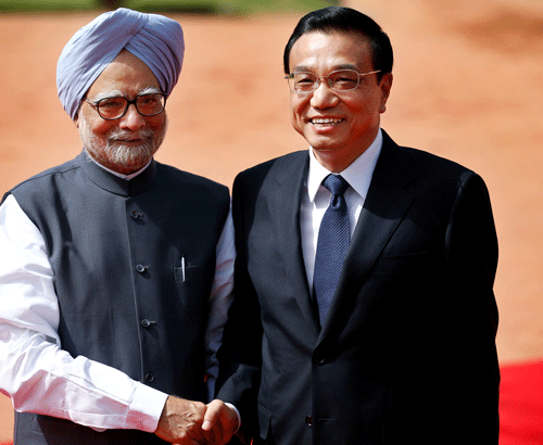 Indian Prime Minister Manmohan Singh, left, shakes hands with Chinese Premier Li Keqiang on his arrival at the Indian Presidential Palace for his ceremonial reception in New Delhi, India, Monday, May 20, 2013. Just weeks after a tense border standoff, China's new premier visited India on Sunday on his first foreign three-day trip as the neighboring giants look to speed up efforts to settle a decades-old boundary dispute and boost economic ties. (AP Photo