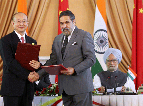 Minister for Commerce & Industry and Textiles, Anand Sharma and his Chinese counterpart Gao Hucheng exchange document files after signing an agreement in the presence of Prime Minister Manmohan Singh and Chinese Premier Li Keqiang at a press conference in New Delhi on Monday. PTI Photo