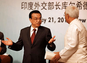 Chinese Premier Li Keqiang, center, gestures as he talks to Indian External Affairs Minister Salman Khurshid, right, at an event organized by Indian Council of World Affairs (ICWA), in New Delhi, India, Tuesday, May 21, 2013. Keqiang is on a three-day visit to India to discuss bilateral and trade ties. (AP Photo/ Saurabh Das)