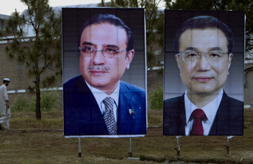 A man walks next to huge portraits of Chinese Premier Li Keqiang, right, and Pakistani President Asif Ali Zardari, left, displayed near the presidency in Islamabad, Pakistan. Keqiang will arrive in Islamabad on May 22 on a two day official visit to hold talks with Pakistani leadership to discuss international, regional issues and enhance co-operation in bilateral ties. (AP Photo