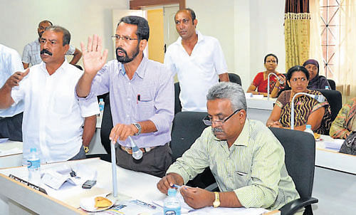 Members Chummi Devaiah, Abdul Razak, Muneer Ahamed, and Ashraf make a point at the Madikeri CMC meeting held on Wednesday. DH Photo